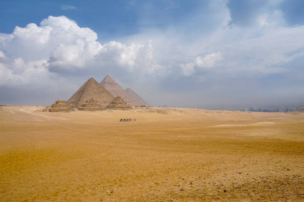 istock The camel caravan is in front of the Egyptian pyramids. 1128749084