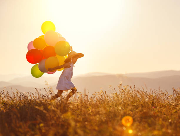 istock . happy child with balloons at sunset in summer 1128750418