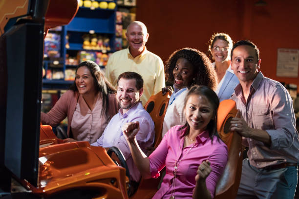 istock Team building at amusement arcade, playing racing game 1128750433