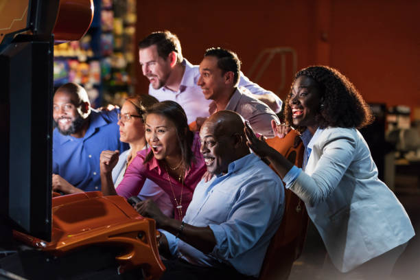 istock Team building at amusement arcade, playing racing game 1128750565