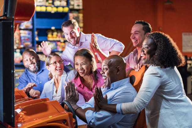 istock Team building at amusement arcade, playing racing game 1128751245