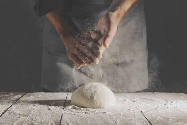 Chef making fresh dough for baking bread. Closeup with copy space. Horizontal.