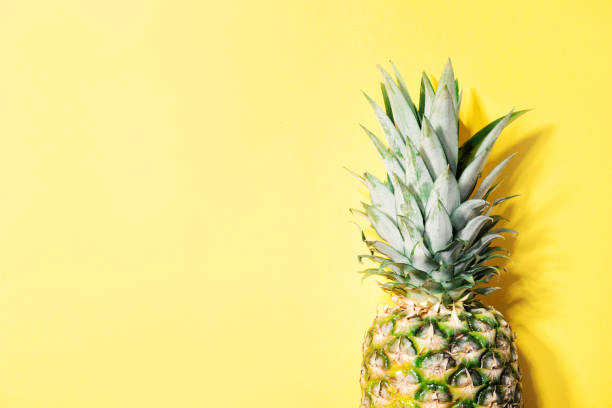 istock Pineapple on yellow color background 1128752537