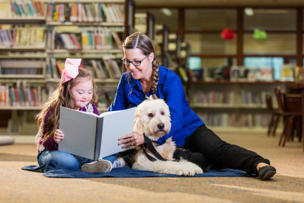 istock Girl with down syndrome in library with therapy dog 1128755804