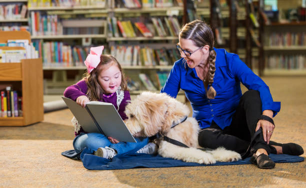 istock Girl with down syndrome in library with therapy dog 1128755852