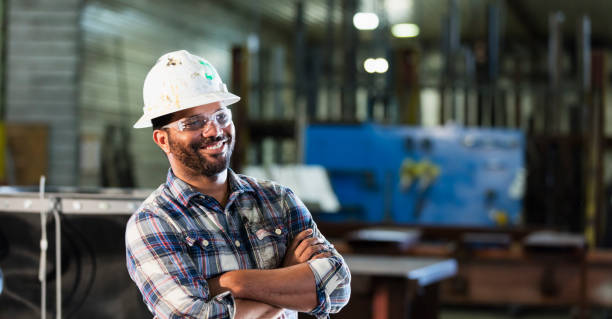 afrikanisch-amerikanischer mann in metall fabrikationsanlage - manager foreman warehouse arms crossed stock-fotos und bilder