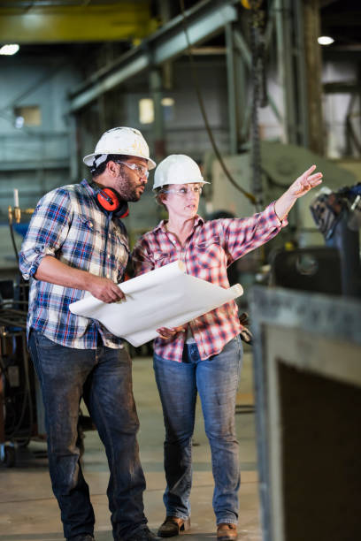 istock Woman working in factory with man 1128759906