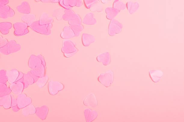 istock Pink background with heart-shaped confetti. 1128760046