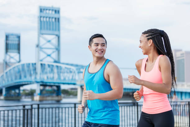 istock Multi-ethnic young couple running on city waterfront 1128761248