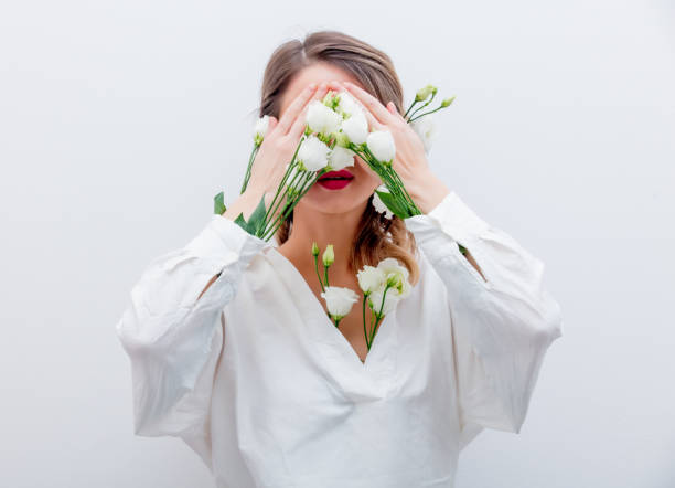 istock Beautiful woman with white roses in sleeve 1128762403