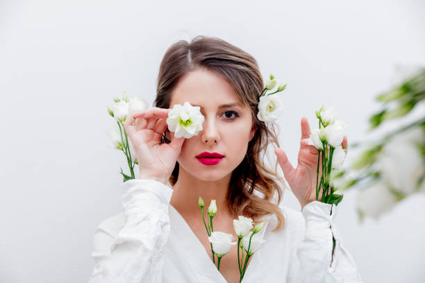 istock Beautiful woman with white roses in sleeve 1128762410