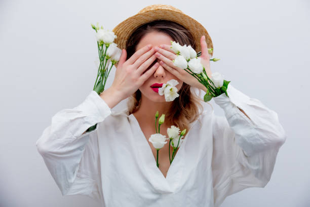 istock Beautiful woman with white roses in sleeves 1128762473