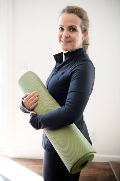 istock Mature woman with yoga mat 1128764211