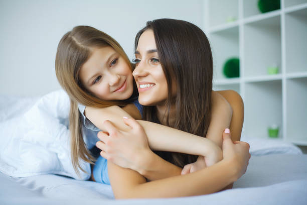 istock Happy mother and daughter lying in bed 1128765472