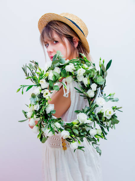 istock Beautiful woman with white roses wreath on white background 1128765901