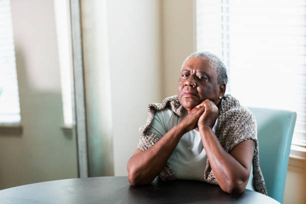одинокая старшая афроамериканка дома - women sadness african ethnicity african descent стоковые фото и изображения