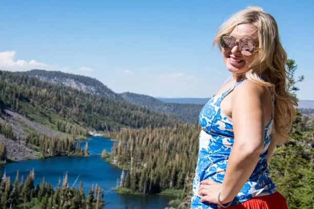 An adult female stands at the top of Twin Lakes overlook in Mammoth Lakes, California, wearing patriotic USA flag colors on the Fourth of July.