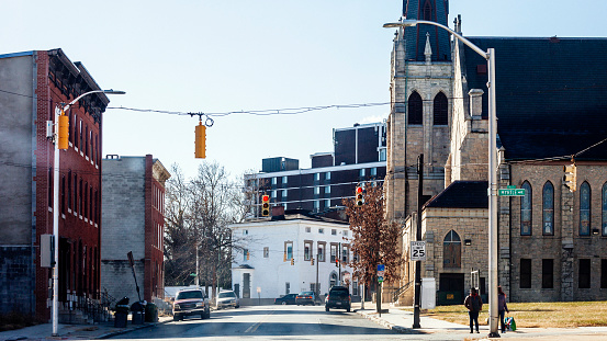Baltimore, Maryland, USA - Few people walking in the street near the church in Upton district.