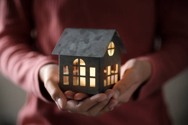 Model house in the palm Miniature house model with illuminated light in the hand emergency shelter stock pictures, royalty-free photos & images