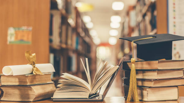 istock E-book, E-learning class and internet online education success with computer laptop, graduation hat, academic cap, mortarboard and degree certificate on books in class or library study room 1128780798