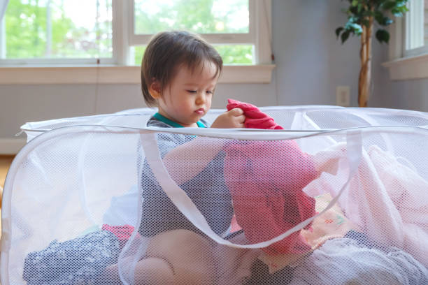 istock Happy toddler boy playing in a laundry basket 1128781693