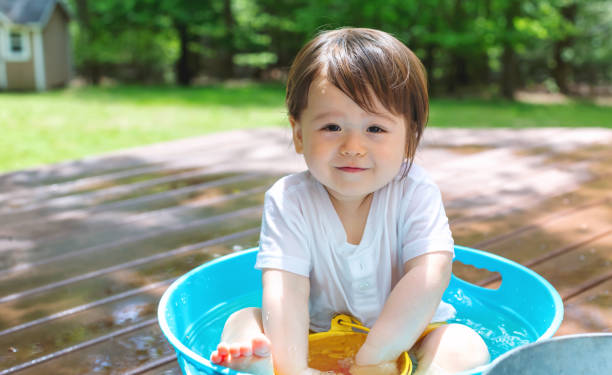 istock Young toddler boy playing with water 1128781696