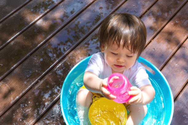 istock Young toddler boy playing with water 1128781697