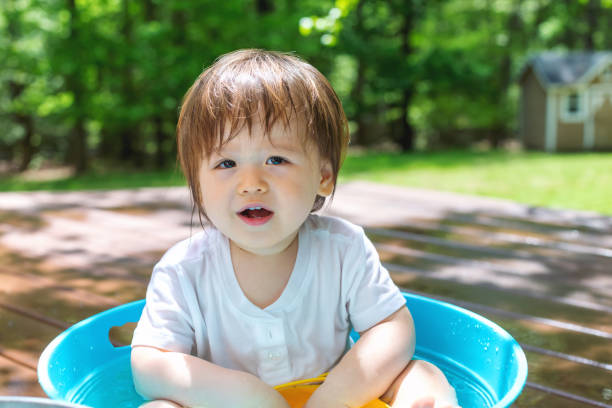 istock Young toddler boy playing with water 1128781699