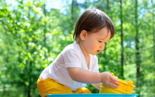 istock Young toddler boy playing with water 1128781881