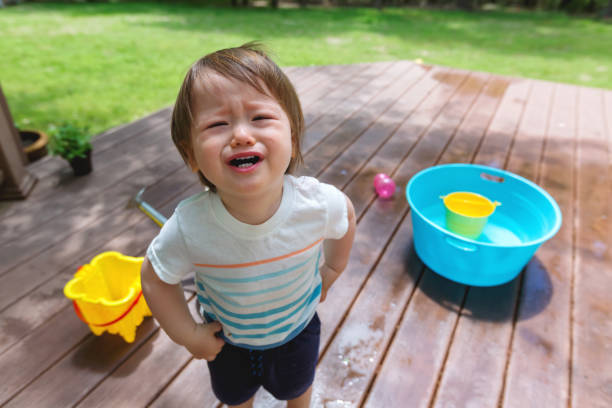 istock Crying toddler boy playing with water 1128782221