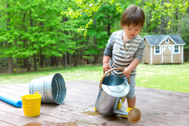 istock Toddler boy playing with a watering can 1128782277