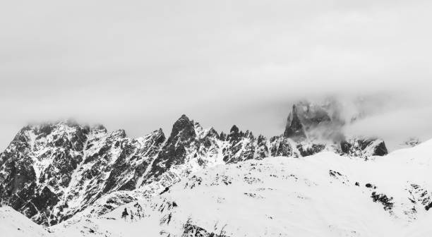istock Rocky mountains in snow and overcast gray sky 1128782432