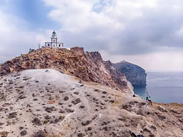 Couple at Akrotiri Lighthouse seatead on the rocks