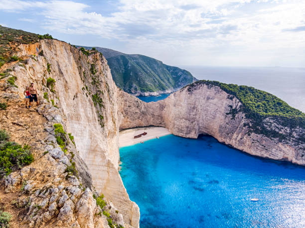 Couple at navagio beach viewpoint in Zante, Zakynthos, Greece