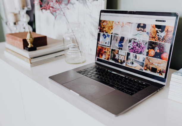 istock Laptop displaying images on a blog on a white table 1128791436