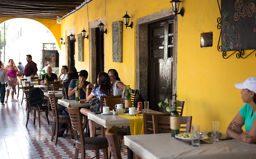 Valladolid, Yucatan, Mexico: Tourists enjoy a meal at a restaurant under the Spanish colonial arches on the central square in Valladolid, Mexico.