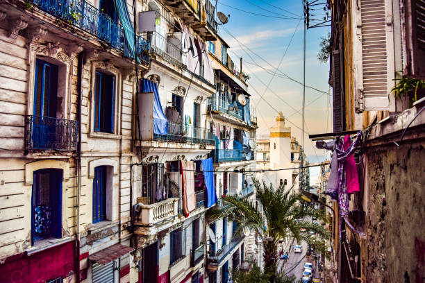 Alley in downtown Algiers Old French-style apartment buildings and North African mosque in Algiers, Algeria, at sunset casbah stock pictures, royalty-free photos & images