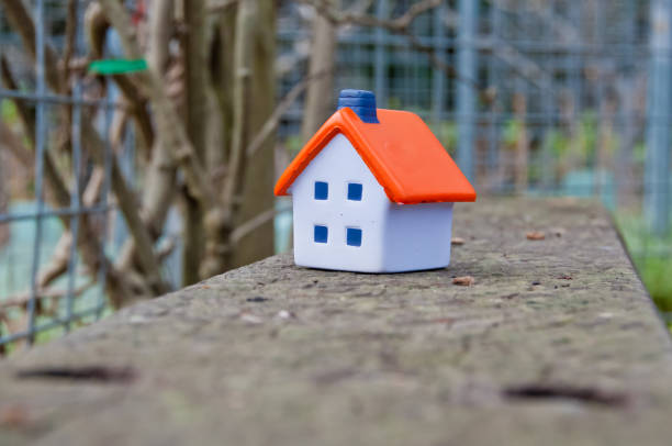 istock Miniature soft toy house on concrete fence 1128801404