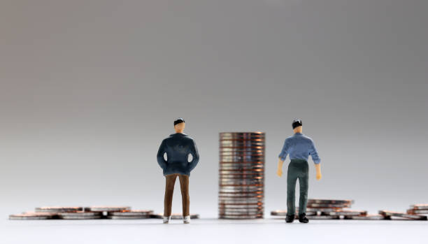 istock Miniature people and coins. 1128802215
