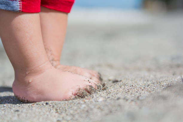 istock Children barefoot in the beach sand 1128803987