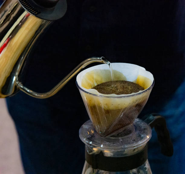 istock Drip coffee brewing, Barista pouring water on coffee ground with filter 1128807922