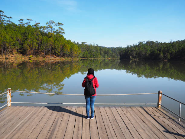 istock woman standing at lake side 1128809126