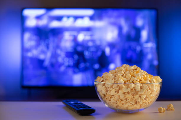 istock A glass bowl of popcorn and remote control. 1128811498