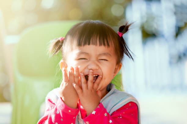 niña asiática linda riendo y jugando peekaboo u ocultar y buscar con la diversión - child surprise little girls human face fotografías e imágenes de stock