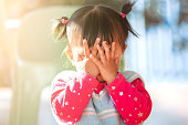 Cute asian baby girl closing her face and playing peekaboo or hide and seek