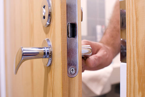 Close-up of a man's hand opening a wooden door The hand of a man opens the door to the bathroom door chain stock pictures, royalty-free photos & images