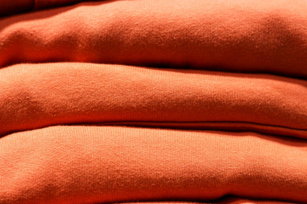 istock Stack of trend Living Coral clothes close-up, texture, background 1128824845