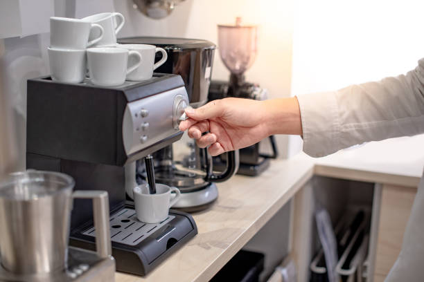 mano maschile del pulsante di torsione barista sulla macchina da caffè nel caffè o nella caffetteria. - pouring coffee human hand cup foto e immagini stock