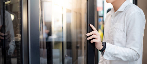 chico asiático comprador apertura armario moderno eligiendo gabinete en la tienda de muebles. concepto de compras de decoración casera - puerta negocio fotografías e imágenes de stock