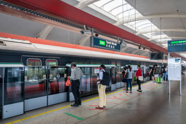 Singapore MRT train and station platform with people waiting. Singapore - January, 2019. Singapore MRT train and station platform with people waiting. The MRT is a rapid transit system forming the major component of the railway system in Singapore. singapore mrt stock pictures, royalty-free photos & images